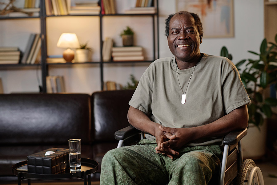 Veteran smiling in wheelchair in living room